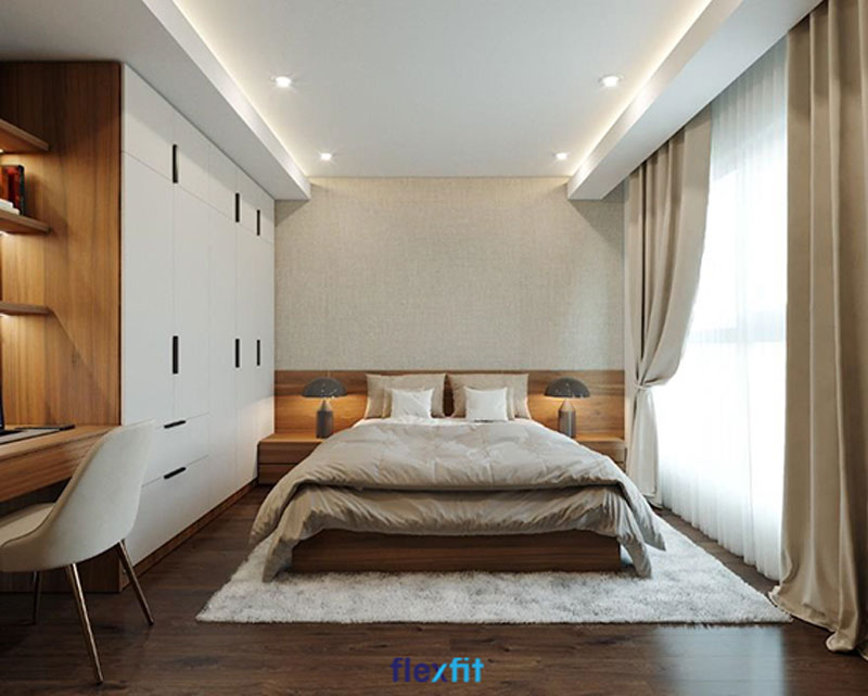 Hệ thống tủ quần áo liền giường lớn trong không gian phòng ngủ rộng rãi, tích hợp nhiều vật dụng tiện lợi như tủ đầu giường và bàn làm việc kèm giá sách.